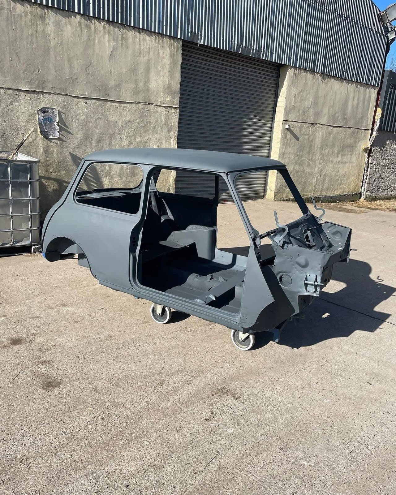 Mini City shell after shotblasting and priming on a rolling dolly